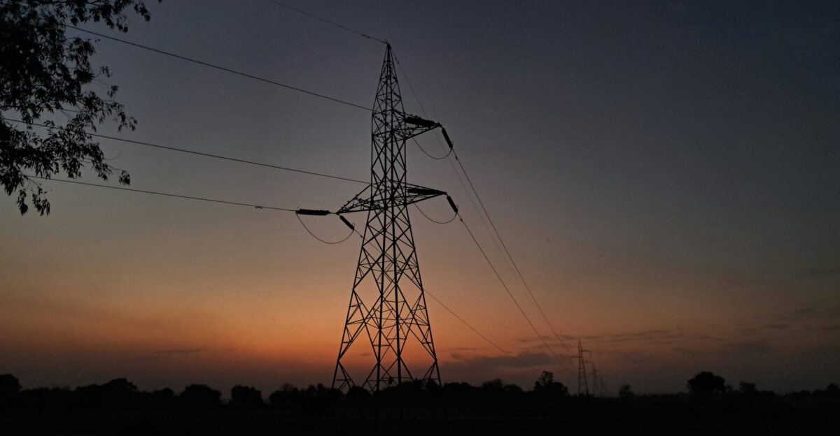 the sun is setting behind an electric tower