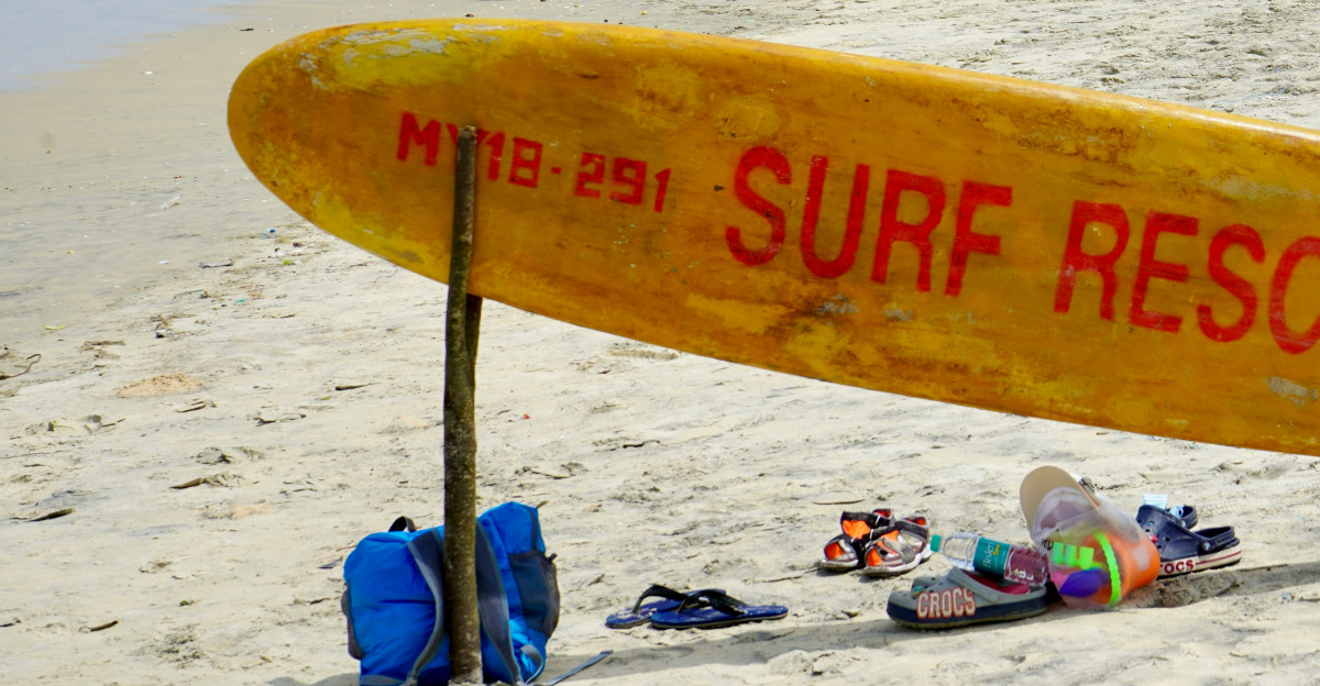 yellow surfboard on white sand beach during daytime