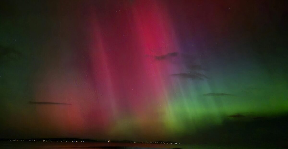 the aurora bore is visible in the sky above the water